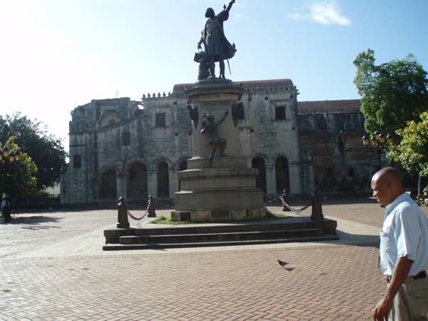 Columbus statue in front of Santo Domingo cathedral, sunlight on the pavement