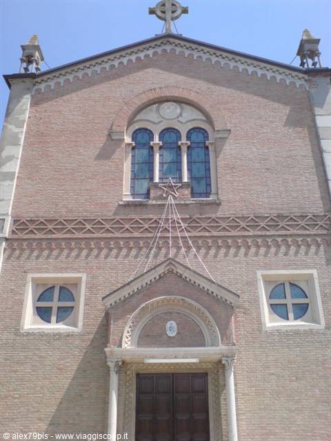 Brick church facade with Celtic cross, blue stained glass windows and entrance portal