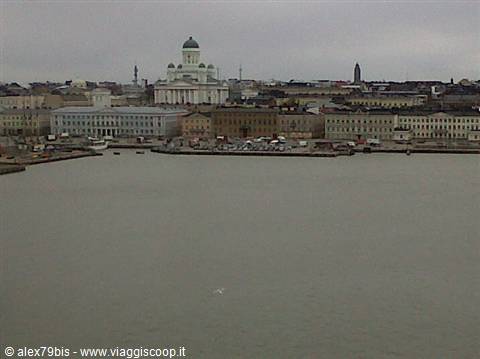 White cathedral with green dome over Helsinki harbor, gray sky