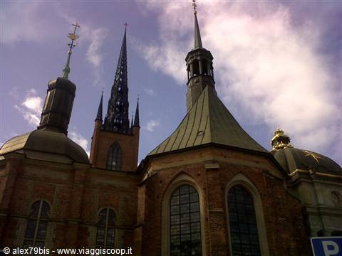 Spires and green copper domes of Riddarholmen Church against white clouds