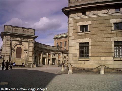 Tourists in the cobbled courtyard of Stockholm Royal Palace among stone walls