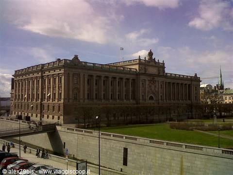 The Riksdag parliament building in Stockholm under pink clouds, cars below
