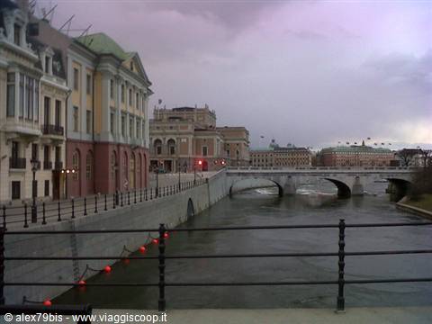 Norrbro bridge over the water in Stockholm, historic buildings under cloudy sky