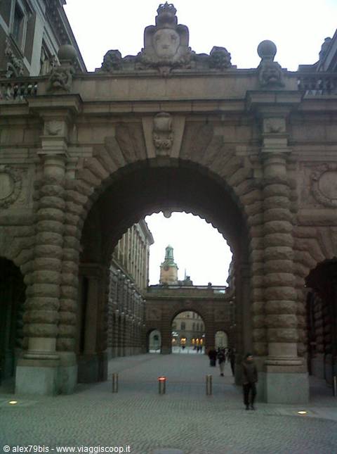 Rusticated stone arch of Stockholm Royal Palace, people walking beneath