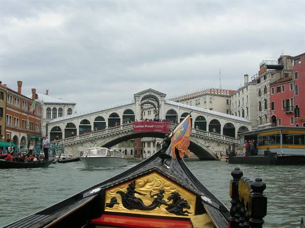 Gilded gondola bow on the Grand Canal toward Rialto Bridge, Venice