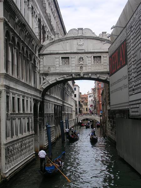 Gondolas beneath the Bridge of Sighs in Venice, daylight on white stone