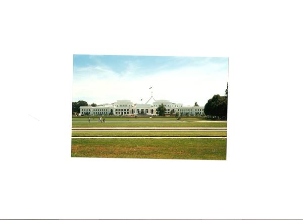 Old Parliament House in Canberra, white facade, lawn and walking visitors