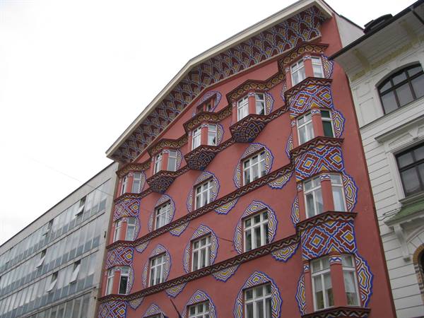 Pink facade painted with colorful geometric folk patterns, Ljubljana