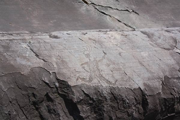 Rock carving of a human figure on grey stone in daylight