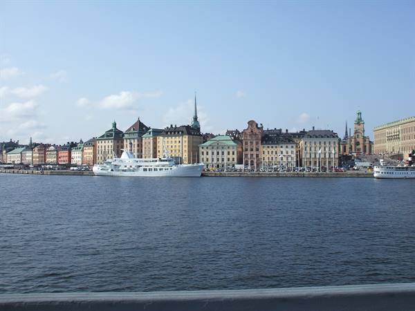 White ship moored in front of Stockholm's colorful buildings, morning light
