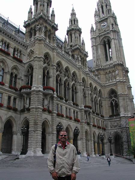 Tourist in front of Vienna's Rathaus, neo-Gothic stone facade with towers