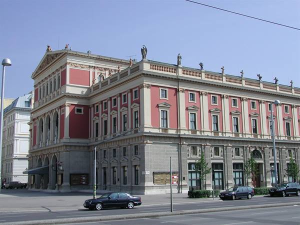 Vienna's Musikverein, red and white facade, rooftop statues, cars passing by