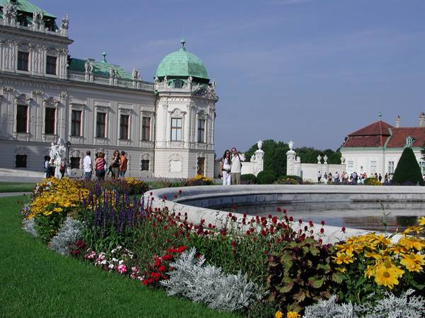 Tourists beside the fountain and flowers at the Belvedere in Vienna