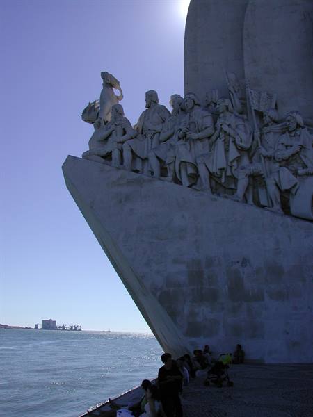 Monument to the Discoveries in Lisbon: stone figures, Tagus river, tourists resting below