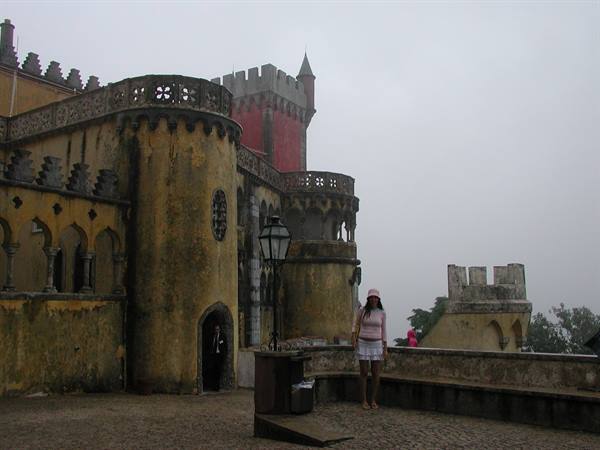 Tourist in the Pena courtyard, yellow walls and red tower in the fog