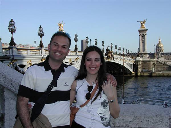 Smiling couple on Pont Alexandre III, with the Seine and golden statues