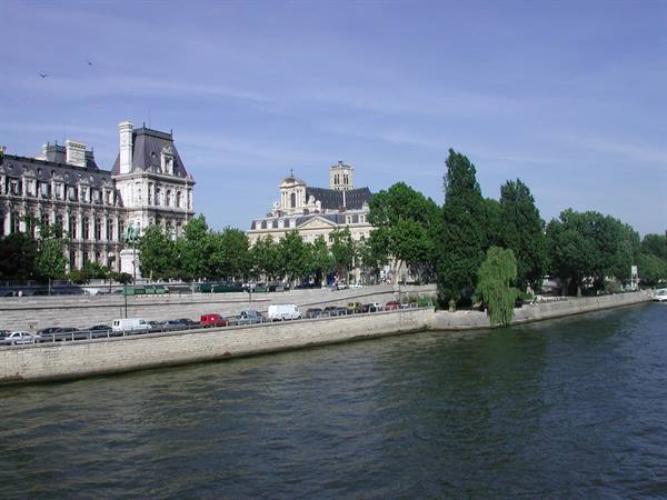 Paris Hôtel de Ville along the Seine, cars parked under a blue sky