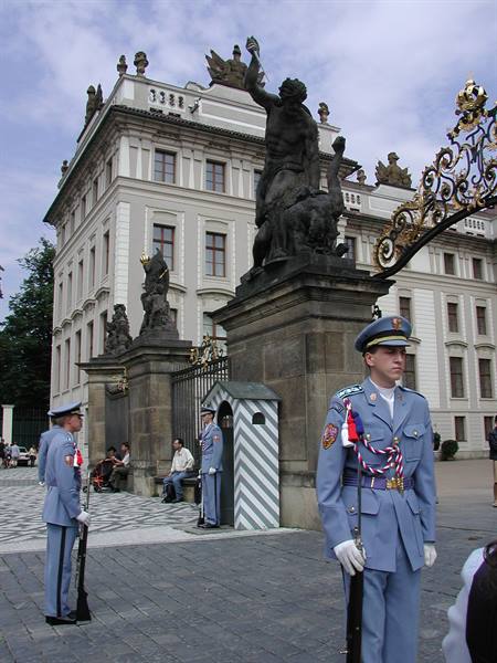 Guards in blue uniforms at the Prague Castle gate, battling Titans statues