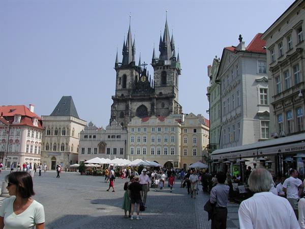 Tourists stroll across Old Town Square in front of the Týn Church in Prague