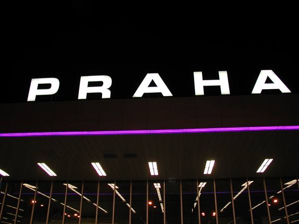 Illuminated PRAHA sign at night on building with purple lighting