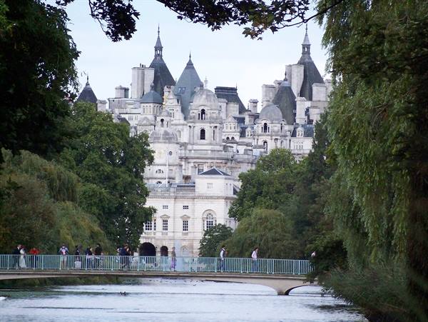 Tourists crossing the St James's Park lake bridge, Whitehall's spires behind