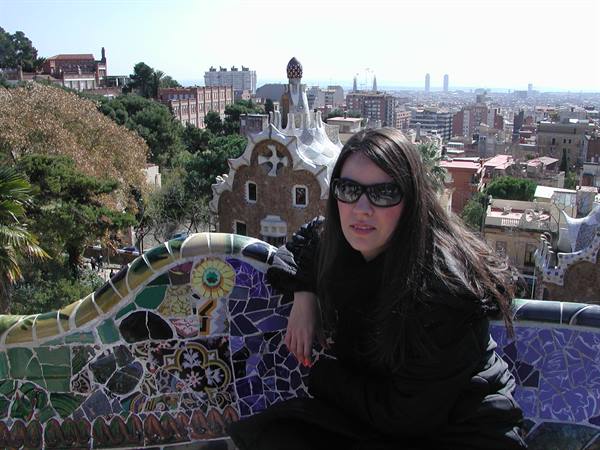 Girl in sunglasses on the mosaic bench at Parc Güell, Barcelona