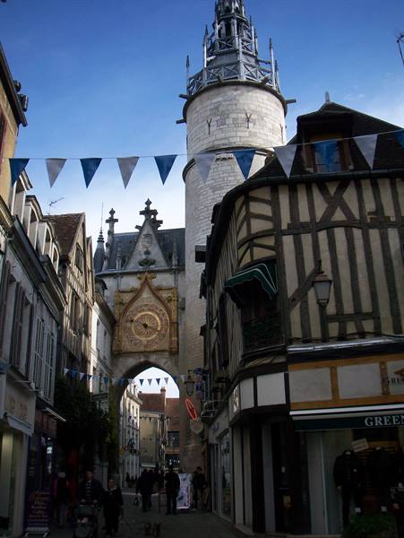 Clock tower in Auxerre among half-timbered houses and bunting