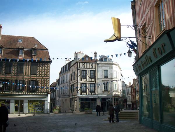 Square with half-timbered houses and a golden boot shop sign