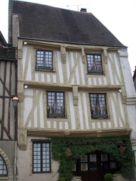 Half-timbered house with wooden beams, plastered facade, ivy covering the entrance