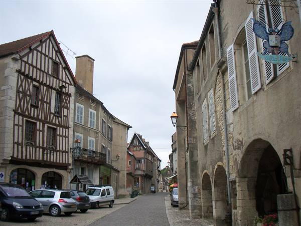 Timbered houses and stone arcades along the cobbled street of Noyers