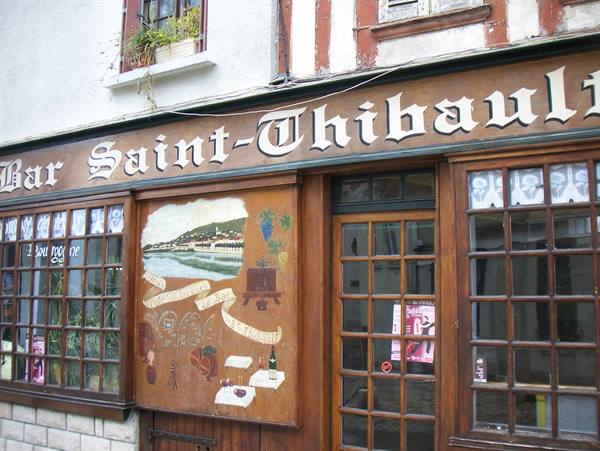 Wooden sign of Bar Saint-Thibault with painted mural on timbered facade