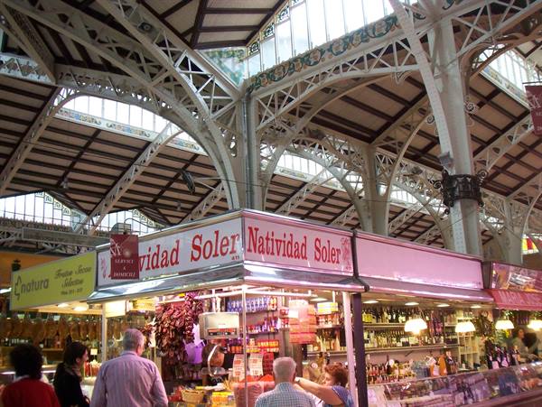 Natividad Soler stall inside Valencia's Mercado Central, iron structure, shoppers buying food