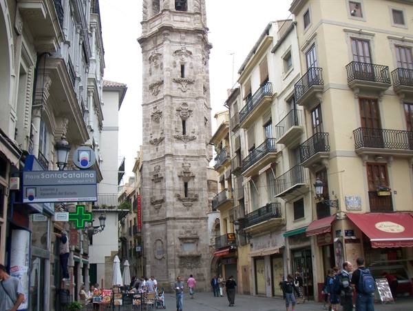 Baroque Santa Catalina tower in Valencia among balconied buildings and pedestrians