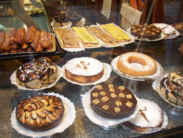 Apple, nut and cream cakes displayed in a bakery window