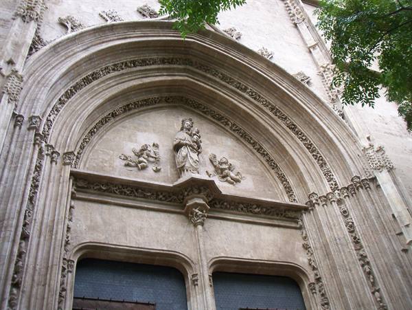 Gothic stone portal with Madonna statue and carved angels