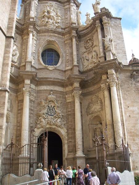 Tourists in front of the baroque stone facade of Valencia Cathedral