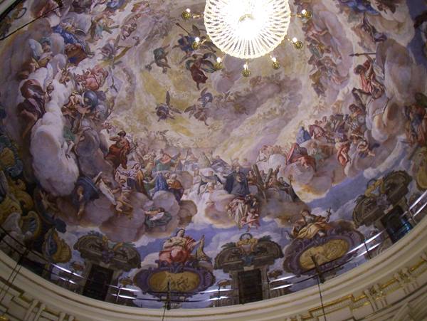 Baroque frescoed dome ceiling with glowing golden chandelier