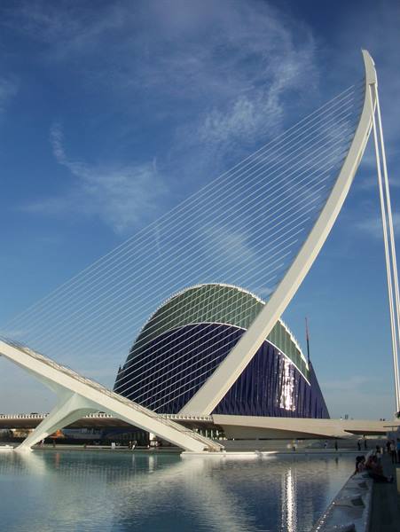 White slanting cable-stayed bridge before the blue dome of L'Àgora, Valencia