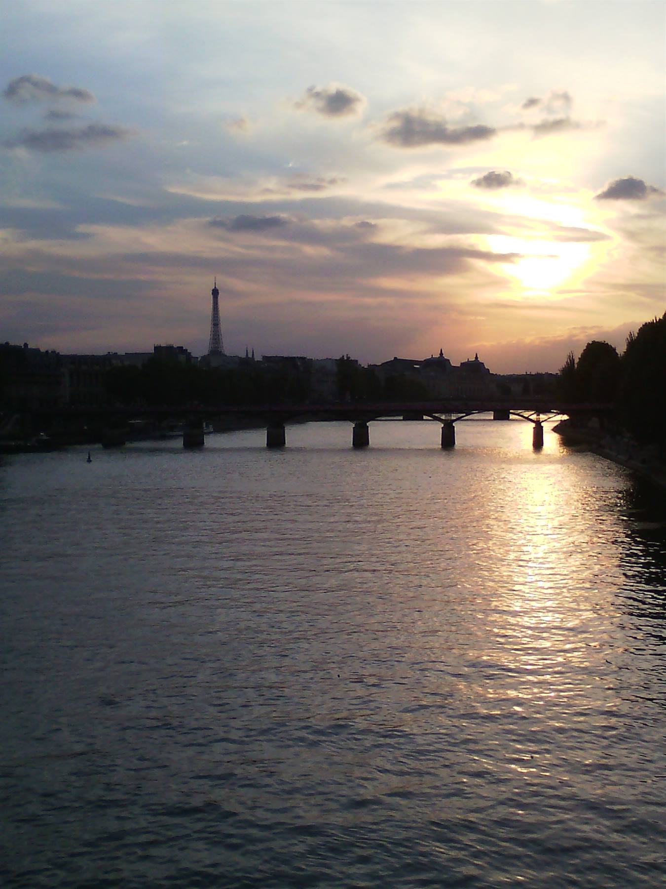 La Senna a Parigi con la Torre Eiffel e un ponte al tramonto