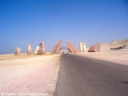 Desert road with pink stone monuments under a clear blue sky