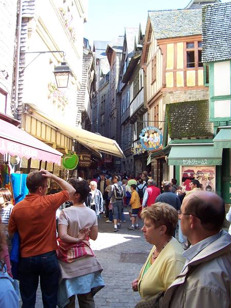 Tourists crowding the narrow street of Mont Saint-Michel among half-timbered houses