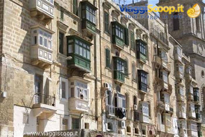 Limestone facades with enclosed wooden balconies and bell tower in Valletta