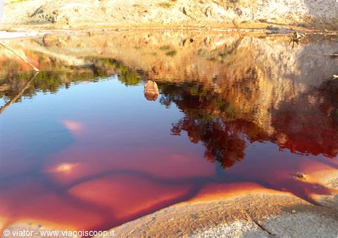 Red and orange waters reflecting among the rocks of Rio Tinto mines