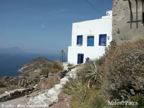 White house with blue windows above path and sea, Milos, Patra