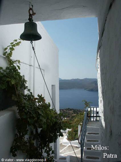 Bronze bell in a whitewashed alley, steps leading to the bay at Milos: Patra