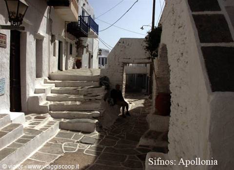 Whitewashed alley with stone steps and seated person, Apollonia