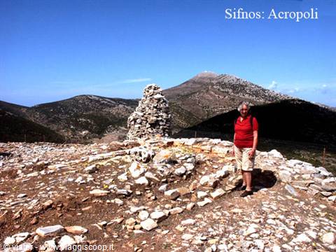 Tourist beside a stone tower at the acropolis of Sifnos
