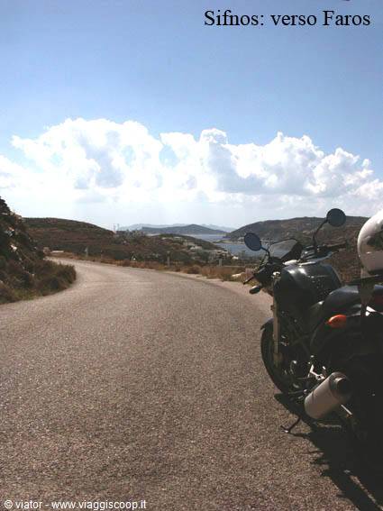 Motorbike parked on the asphalt road toward Faros, Sifnos, under white clouds
