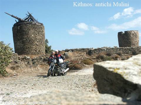 Motorcyclists resting by the ruined stone windmills of Kithnos