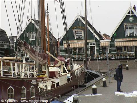 Old wooden sailing ship moored at Volendam harbor in front of wooden houses